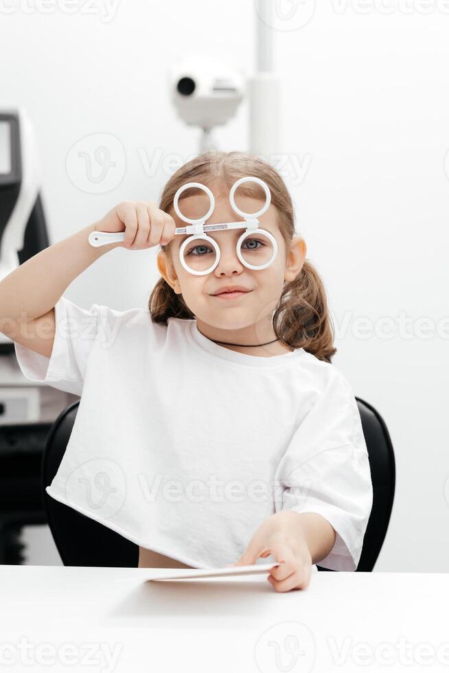 Diagnosis and improvement of vision in modern ophthalmology in young patients. The girl playfully engages in prevention, emphasizing the importance of a comfortable approach to treatment. photo