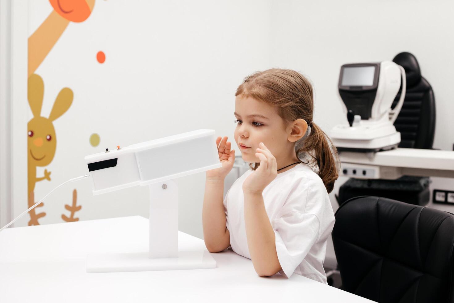 A young girl engages in orthoptic and pleoptic therapy using advanced vision stimulation equipment. Laser eye treatment promotes recovery and enhances vision in a soothing environment photo