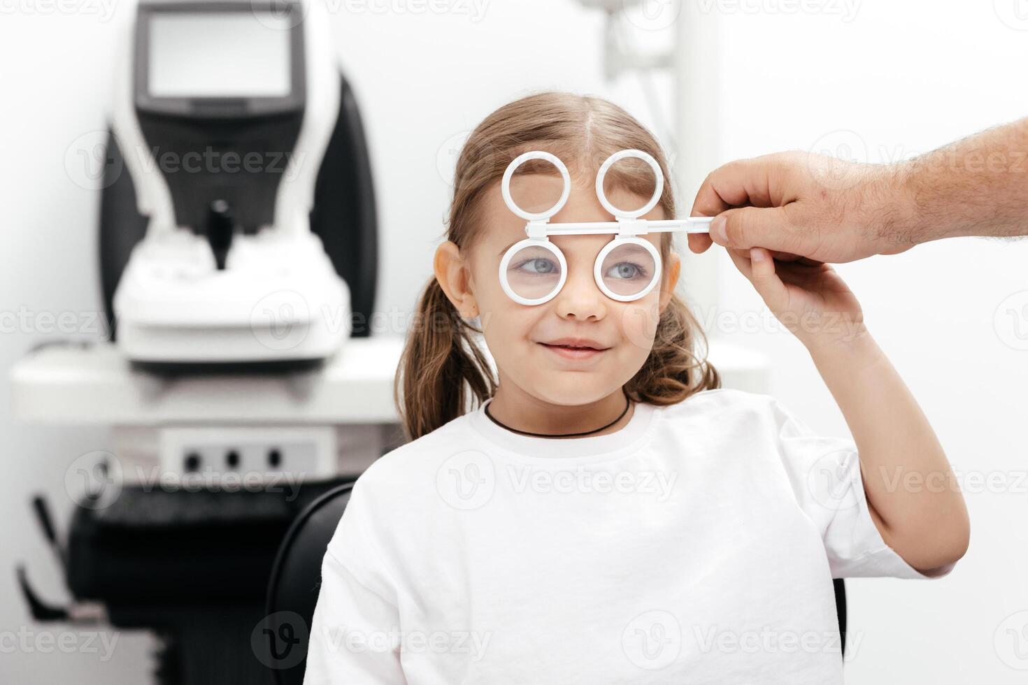 A young girl is practicing her vision skills in a state-of-the-art ophthalmology clinic. Engaging tools and a friendly atmosphere make the experience both fun and beneficial for her development photo