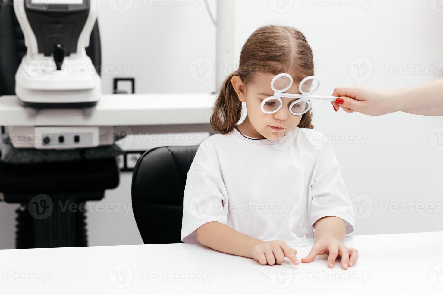 A young girl is practicing her vision skills in a state-of-the-art ophthalmology clinic. Engaging tools and a friendly atmosphere make the experience both fun and beneficial for her development photo