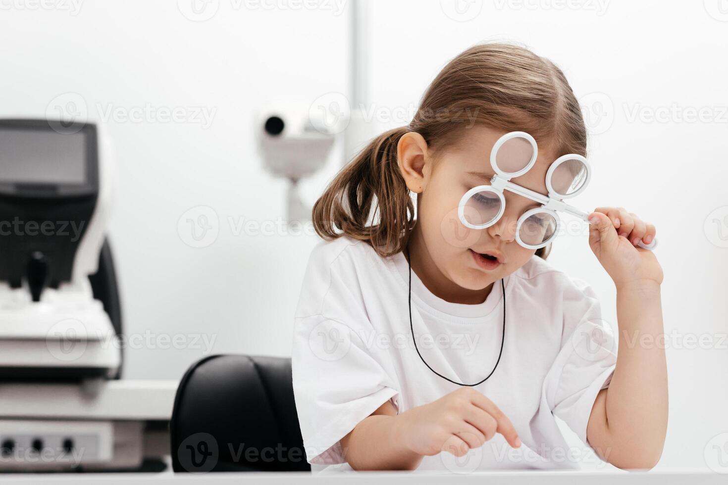 A young girl is practicing her vision skills in a state-of-the-art ophthalmology clinic. Engaging tools and a friendly atmosphere make the experience both fun and beneficial for her development photo