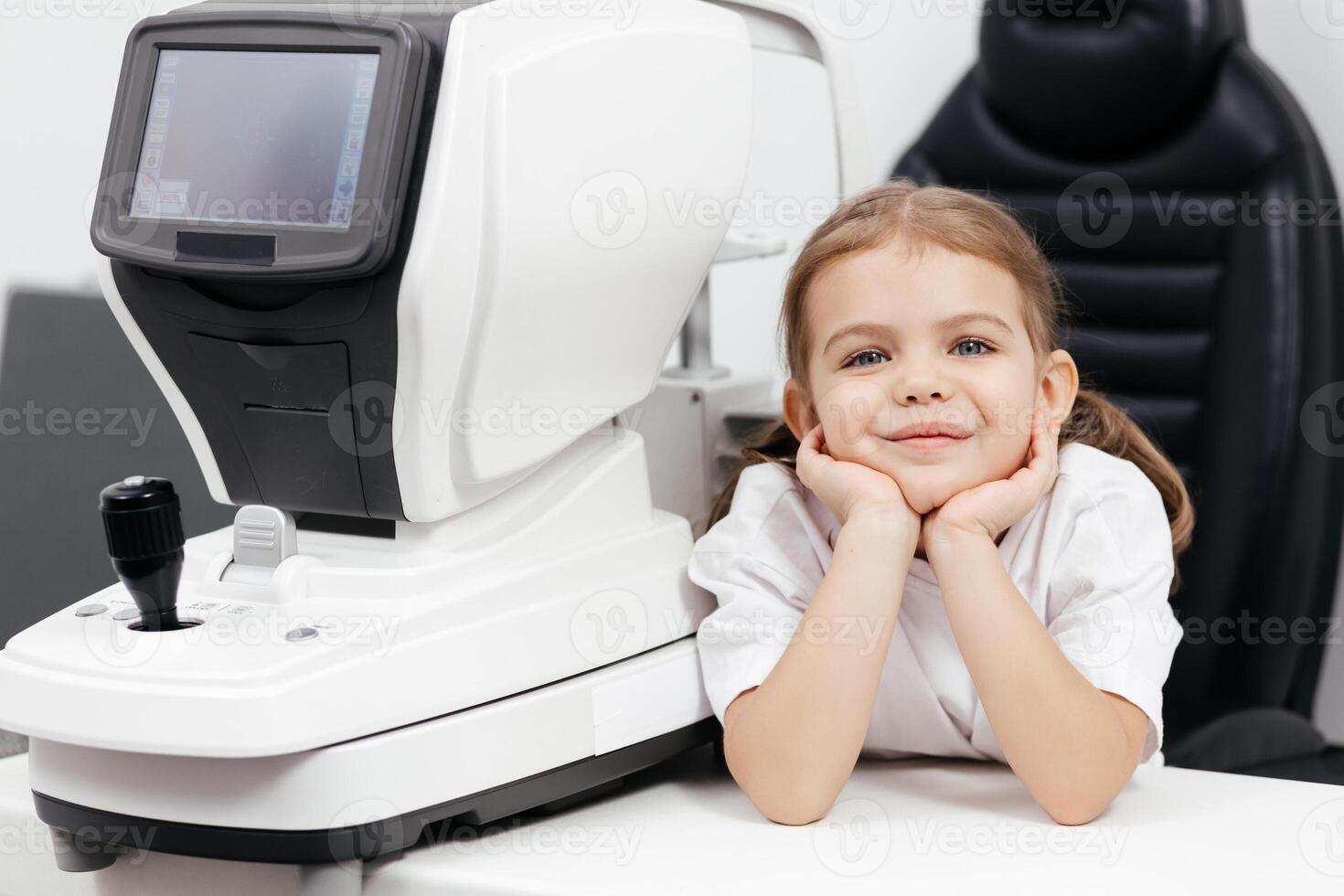 A pediatric optometrist examines the eyes of a little girl. Ophthalmic instrument. An excellent moment to illustrate careful diagnosis and care for children's eye health photo