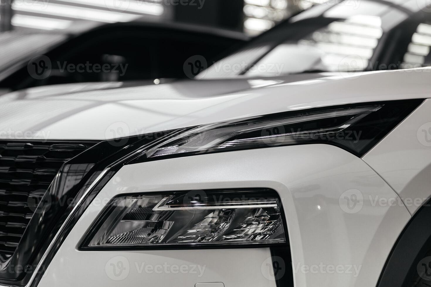 Rear part of new modern white car parked at showroom. Exterior of electric car waiting for sale to customer in light dealership. Car for rent business concept. Automobile leasing and insurance photo