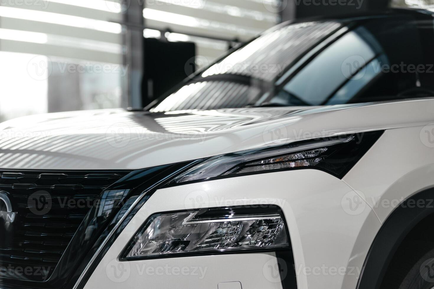 Rear part of new modern white car parked at showroom. Exterior of electric car waiting for sale to customer in light dealership. Car for rent business concept. Automobile leasing and insurance photo
