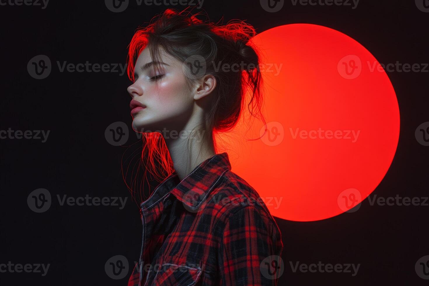 Fashion model posing with red light and red lipstick in studio photo