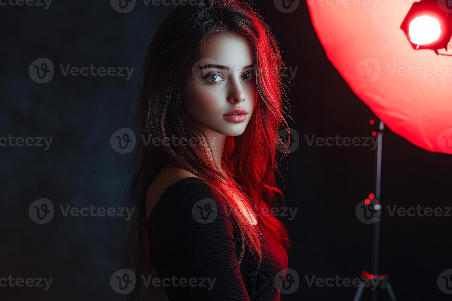 Fashion model posing under red light in studio photo