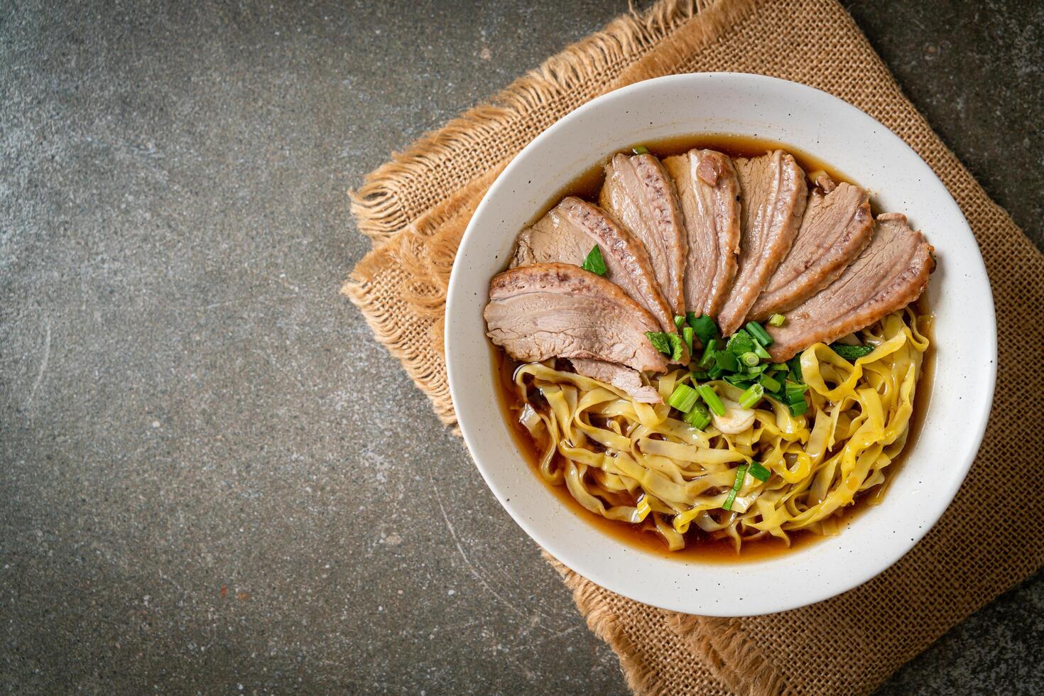 egg noodles with stewed duck in brown soup photo