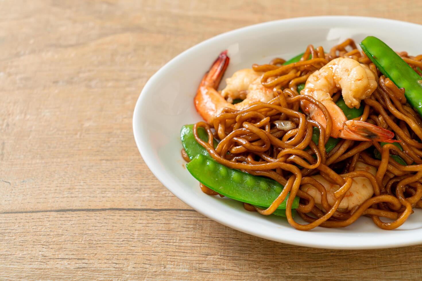 stir-fried yakisoba noodles with green peas and shrimps photo
