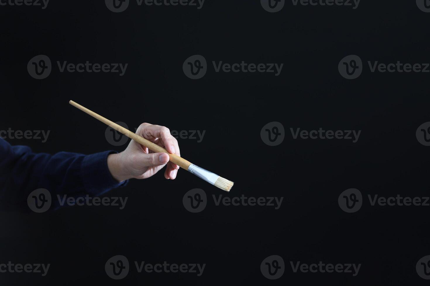 Human hand with brush on black background with copyspace. Hand with a brush, AI image art generative concept photo