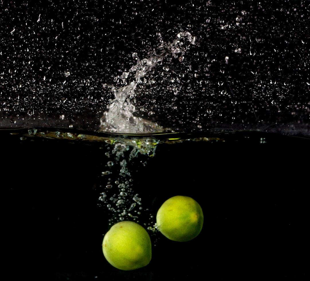 Two green apples falling into water with a splash photo