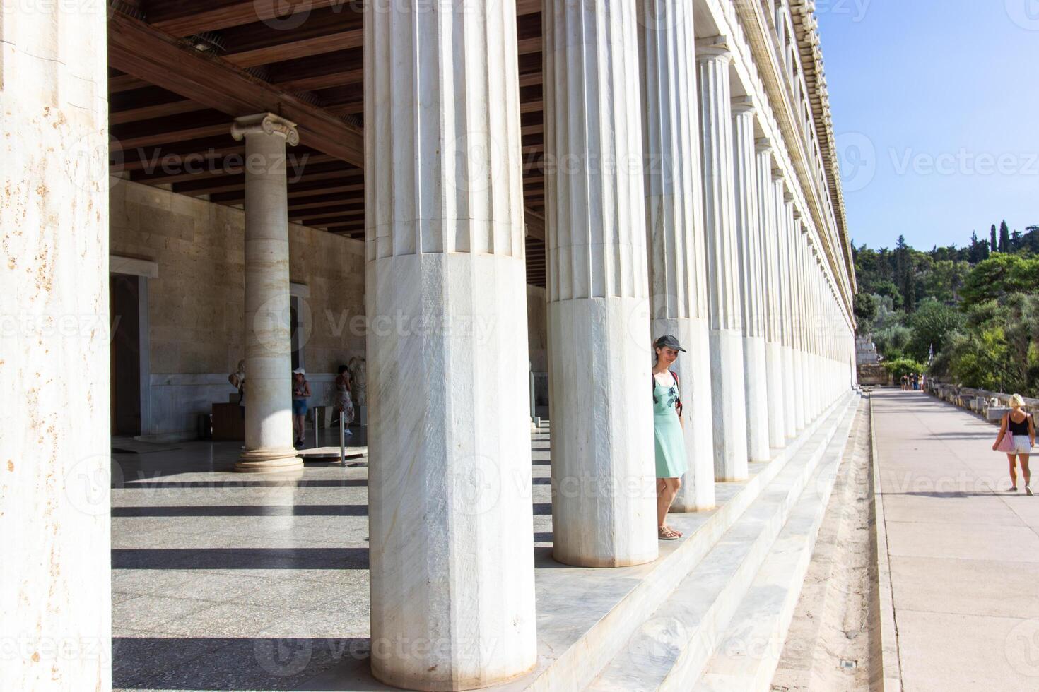 A beautiful woman standing at columns of Housing the Museum of the Ancient Agora. Stoa of Attalos Majestic Hellenistic Architecture in the Agora of Athens photo