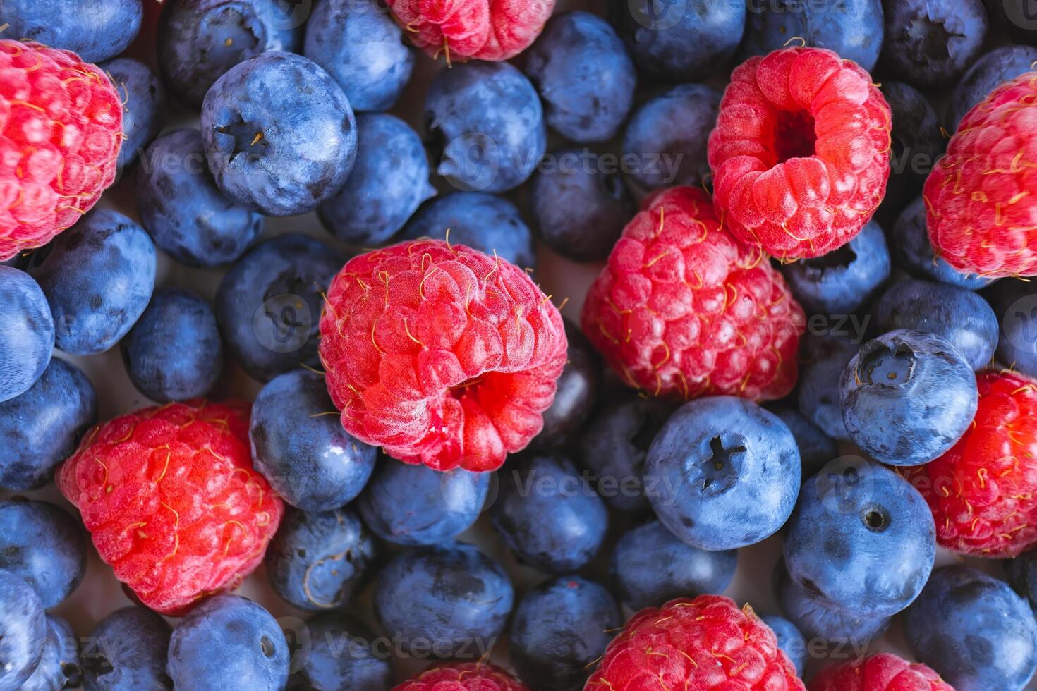 Fresh berry background. Texture of mixture raspberry and blueberry berries close up photo