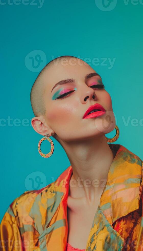 Stylish woman with bold earrings, shaved head, and vibrant makeup, posing with a quirky expression in front of a bright solid color background photo