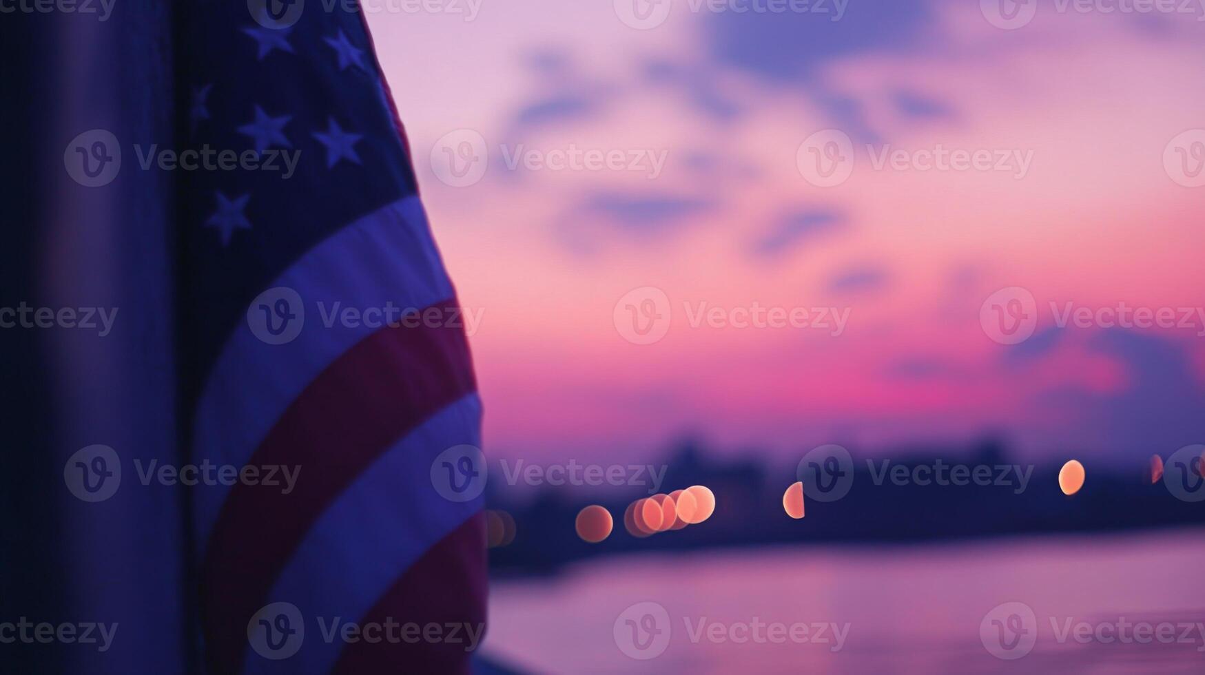 Partial view of the American flag under a pink and purple sunset, sky blurred in the background photo