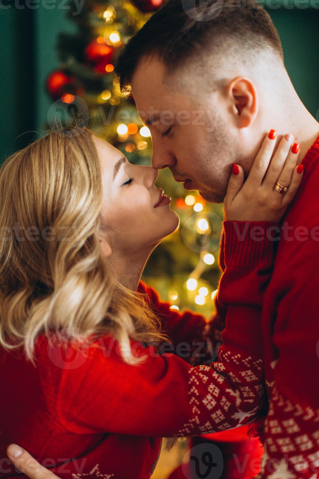 A charming couple in love in traditional christmas red sweaters spend