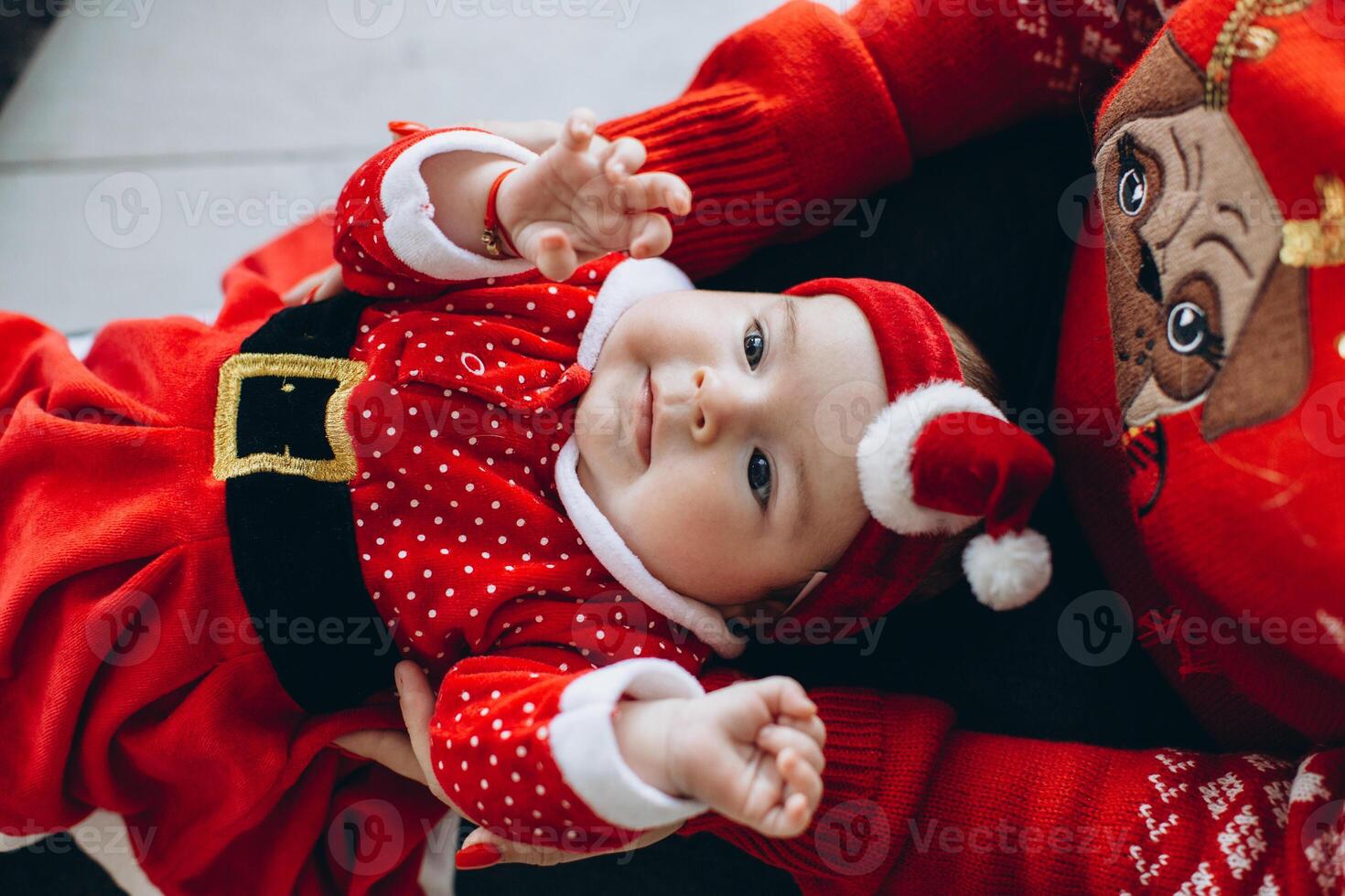 Portrait of mother and little daughter in traditional Christmas clothes in light wooden room photo