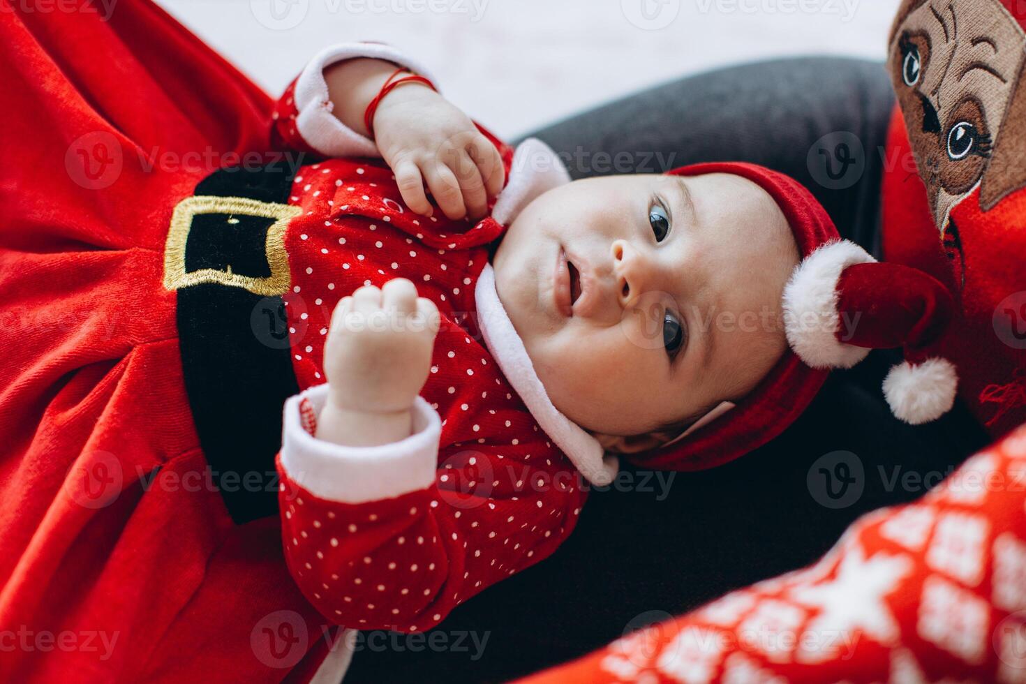 Portrait of mother and little daughter in traditional Christmas clothes in light wooden room photo