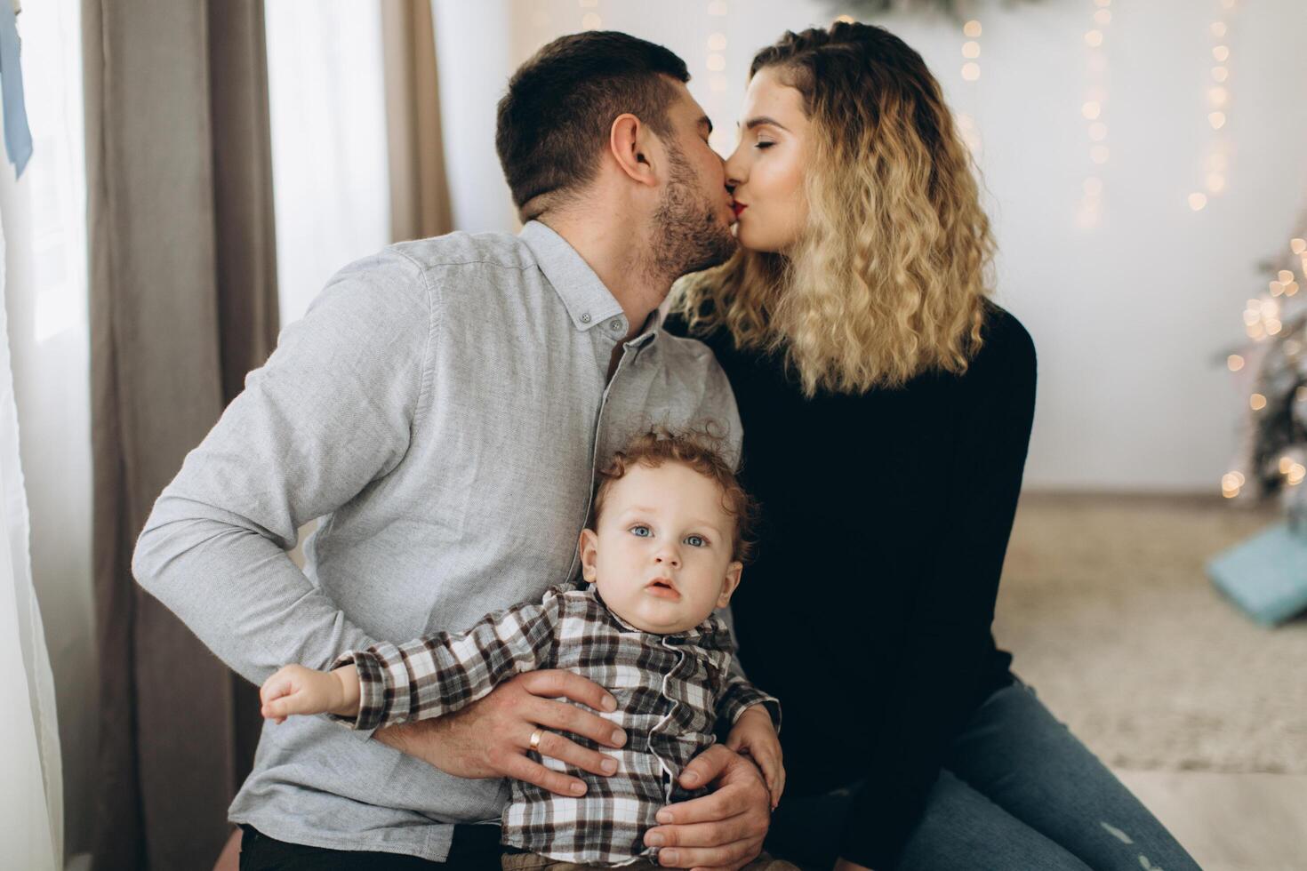 Portrait of happy family of father mother and little curly son celebrating Christmas together at home. photo