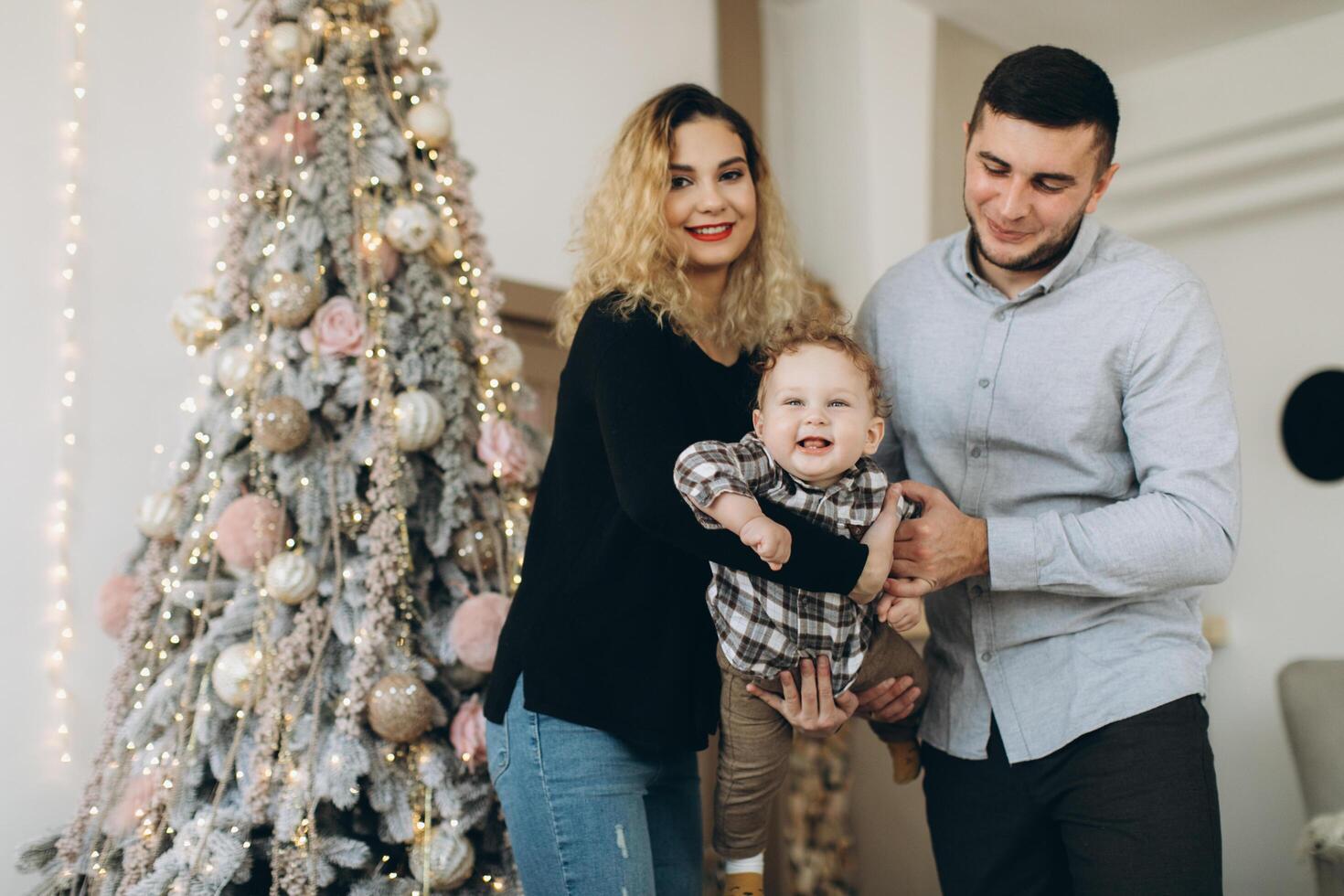 Portrait of happy family of father mother and little curly son celebrating Christmas together at home. photo