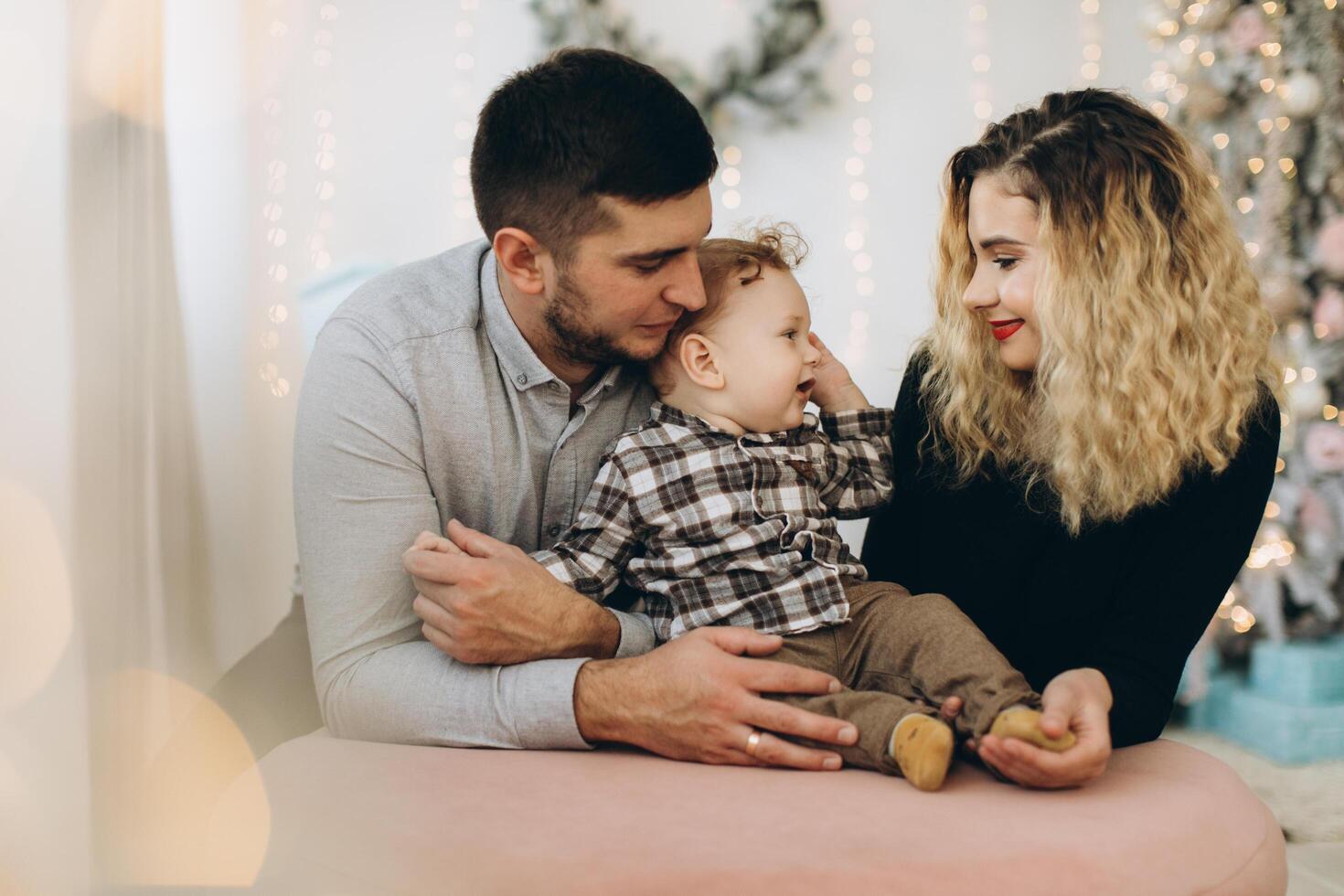 Portrait of happy family of father mother and little curly son celebrating Christmas together at home. photo