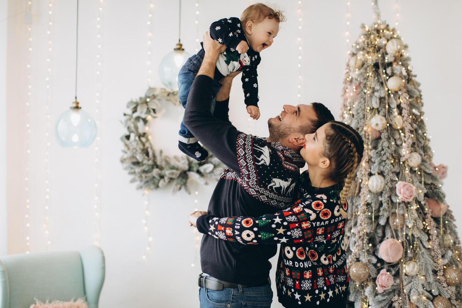 Portrait of happy family of father mother and little curly son celebrating Christmas together at home. photo