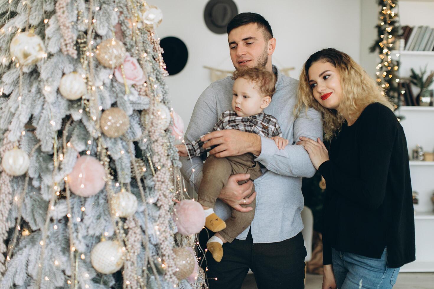 Portrait of happy family of father mother and little curly son celebrating Christmas together at home. photo