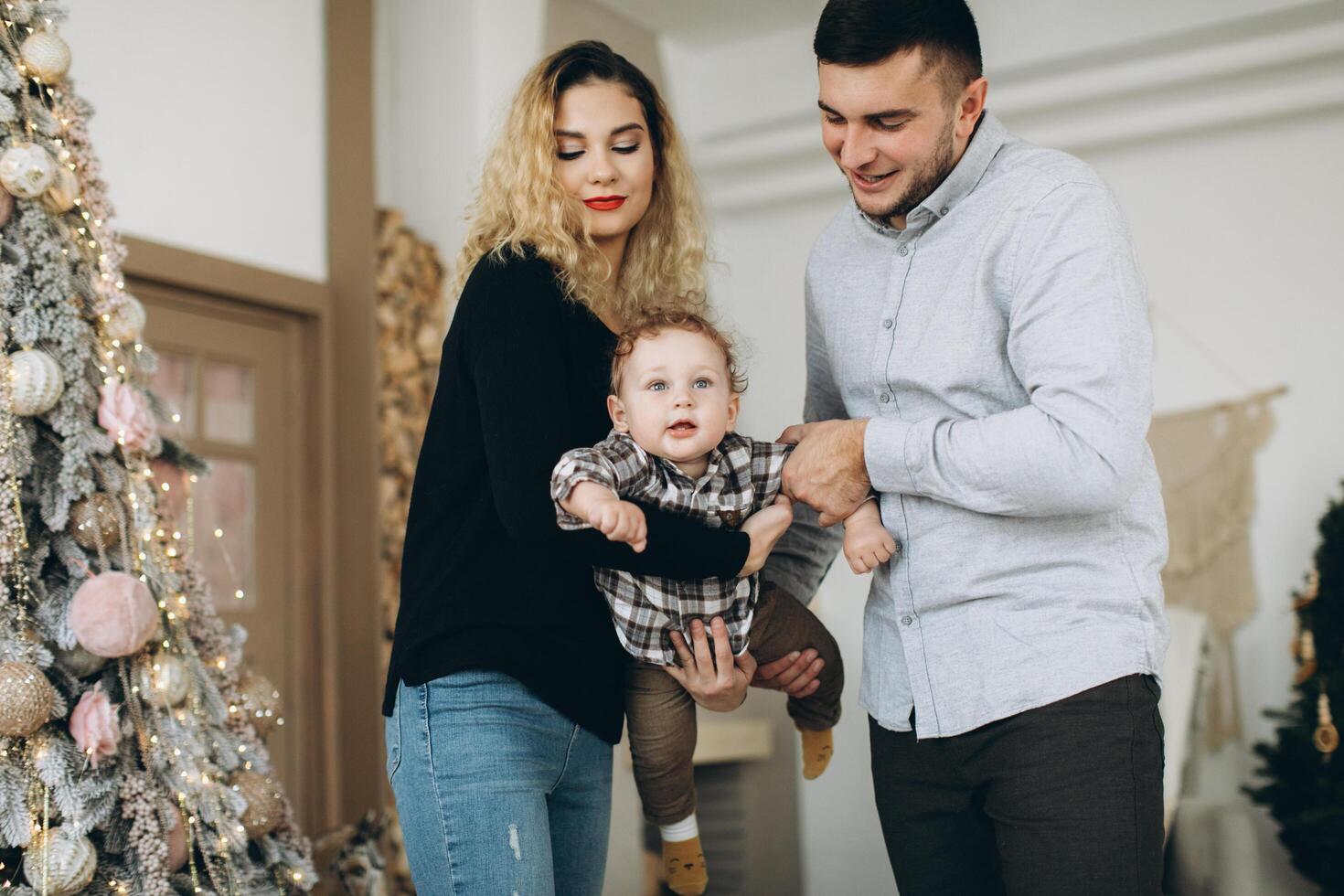 Portrait of happy family of father mother and little curly son celebrating Christmas together at home. photo