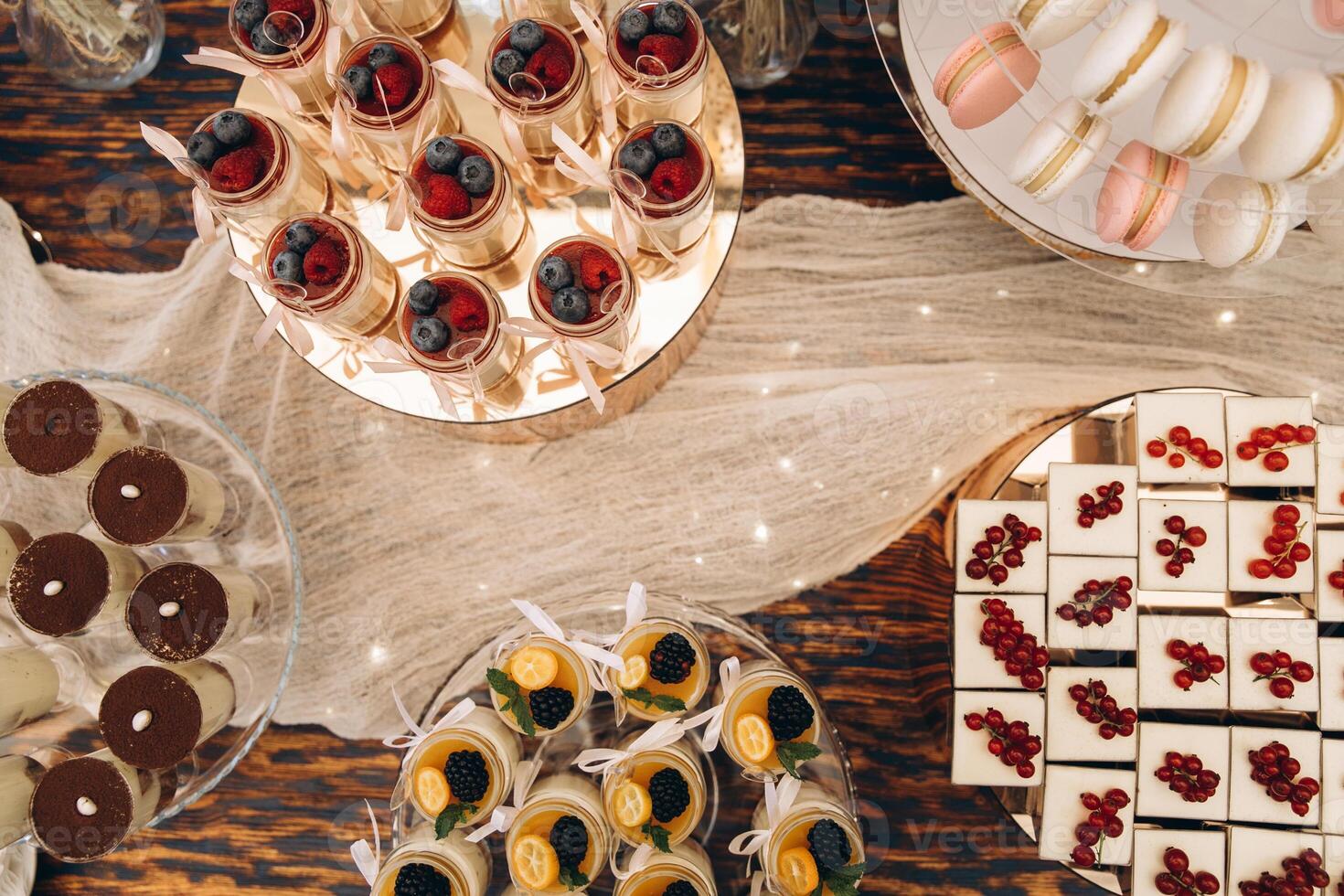 Delicious wedding reception candy bar. Tiramisu, cupcakes, sweetness, macaroons, top view photo