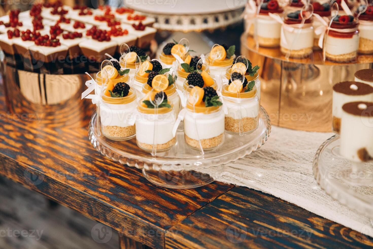 Delicious wedding reception candy bar. Tiramisu, cupcakes, sweetness, macaroons decorated by flowers photo