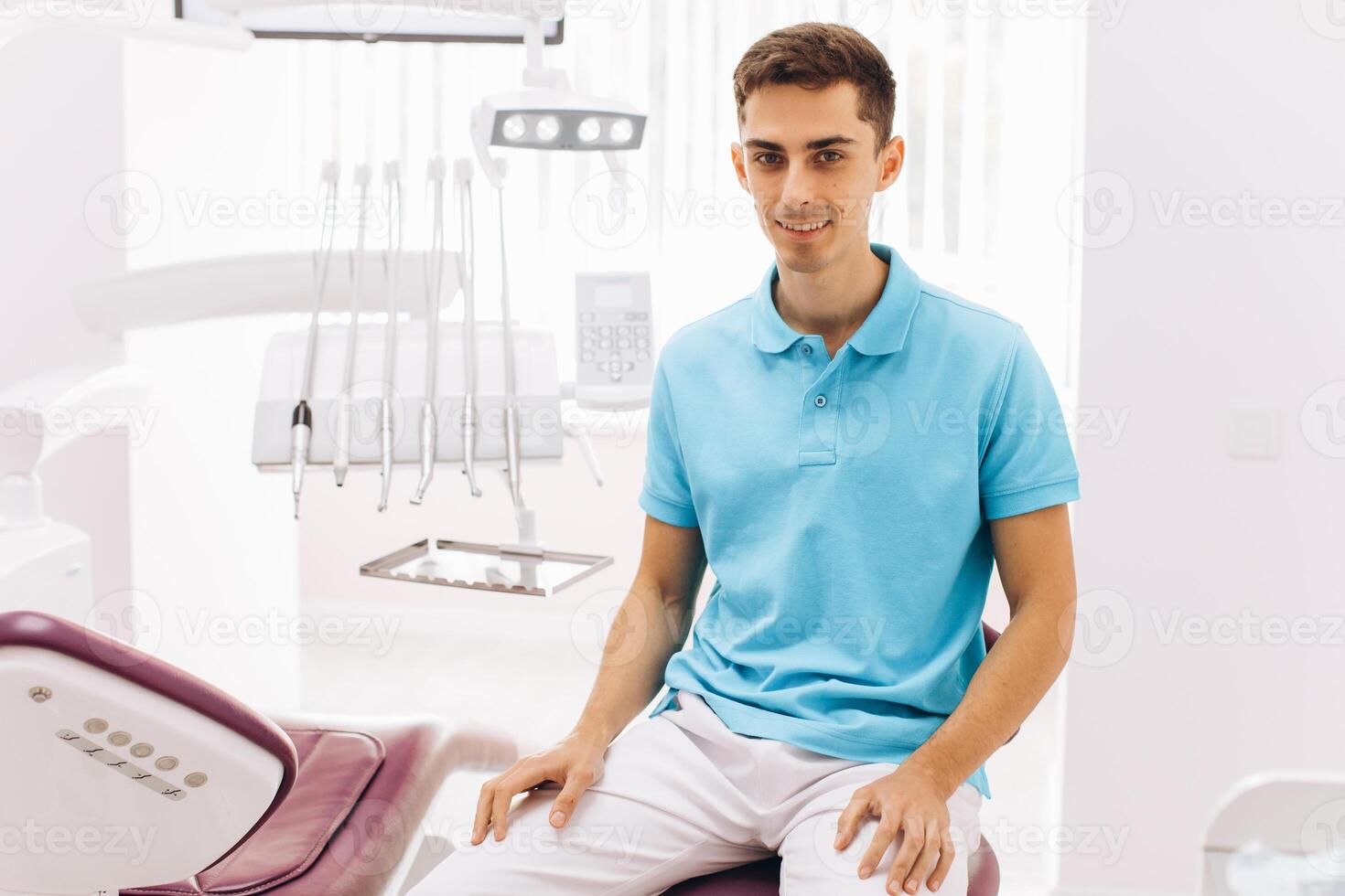 Portrait of a dentist sitting on a dental chair in a clinic photo