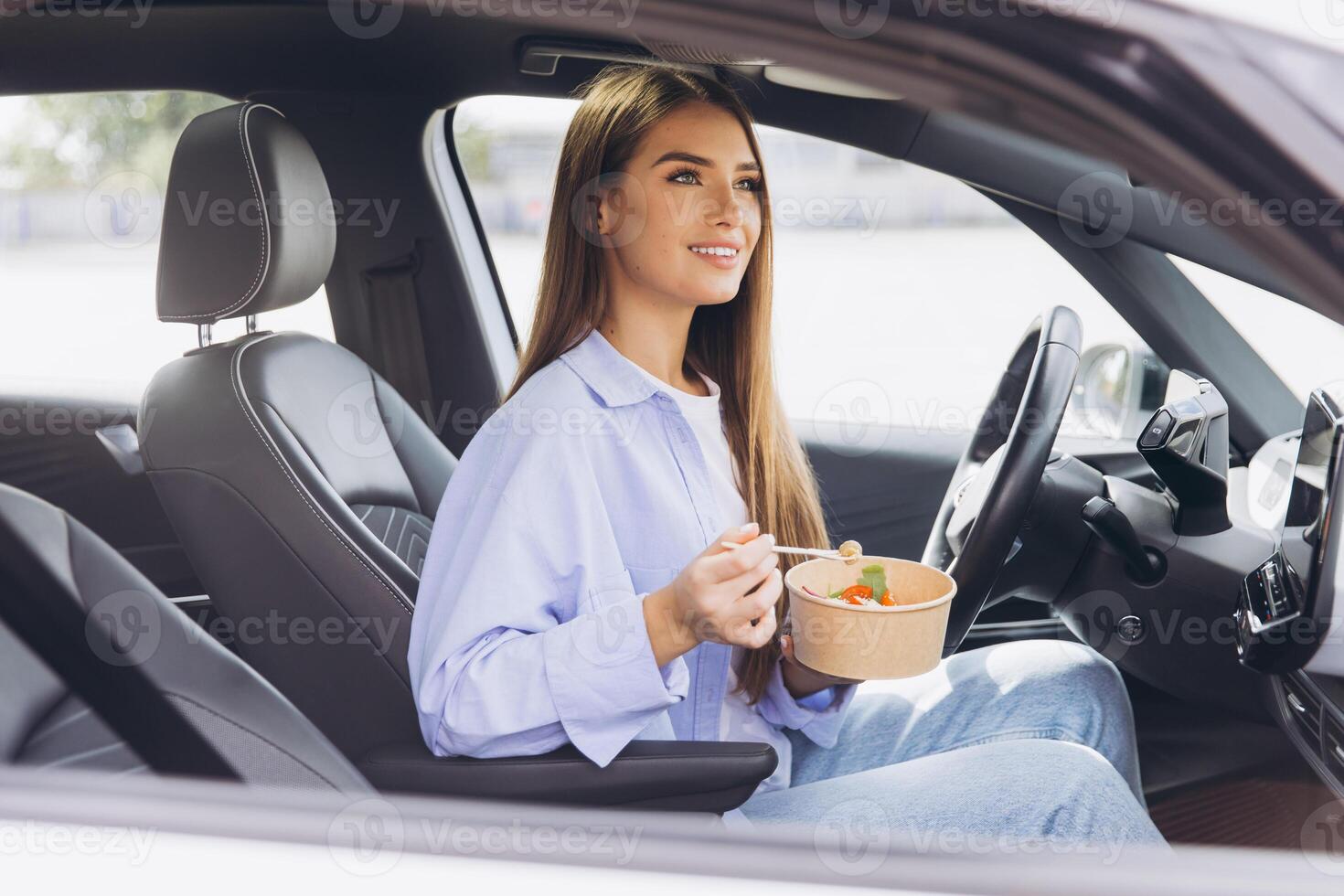 Woman Enjoying a Healthy Meal Inside Her Car While Parked, Emphasizing Convenience and Modern Lifestyle Choices for Busy Individuals On the Go photo