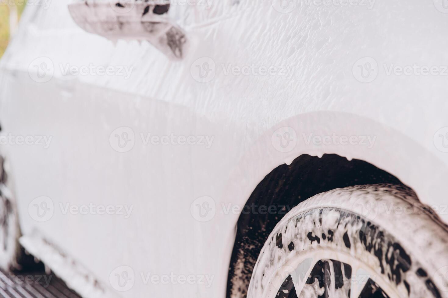 Close-Up of Car Covered in Soap Foam During Washing photo