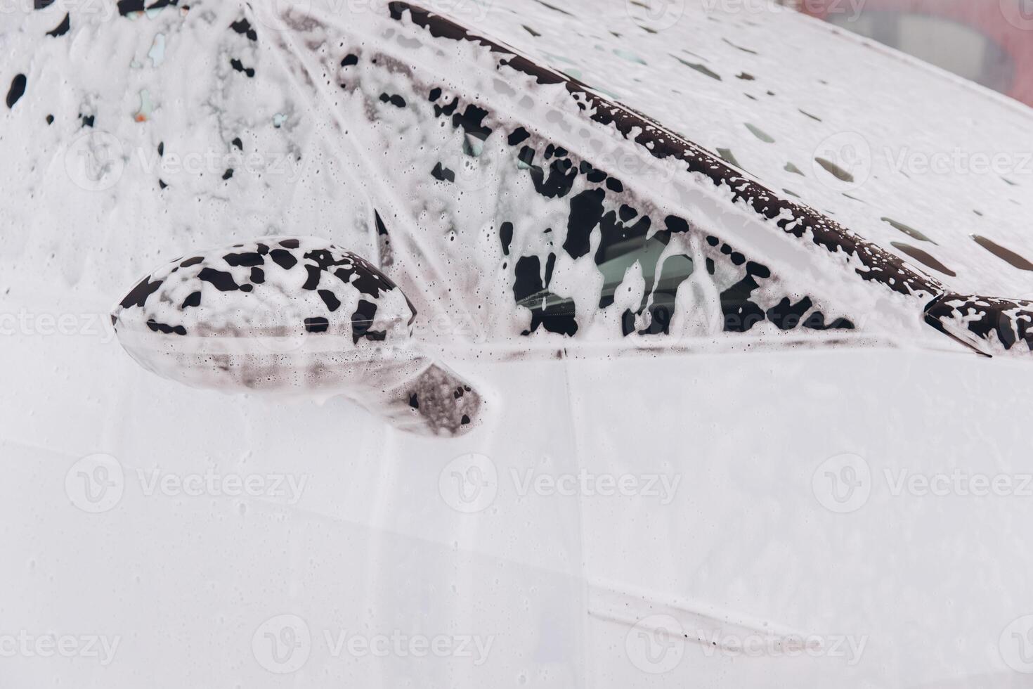 White Car Covered in Soap Suds During Automated Car Wash photo