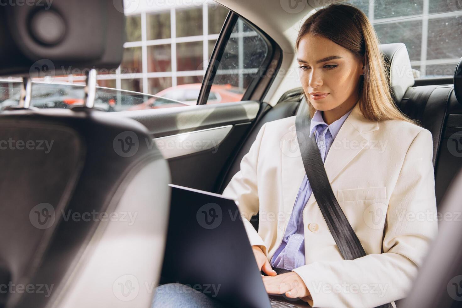 Businesswoman Working Remotely in Car with Laptop on the Go photo