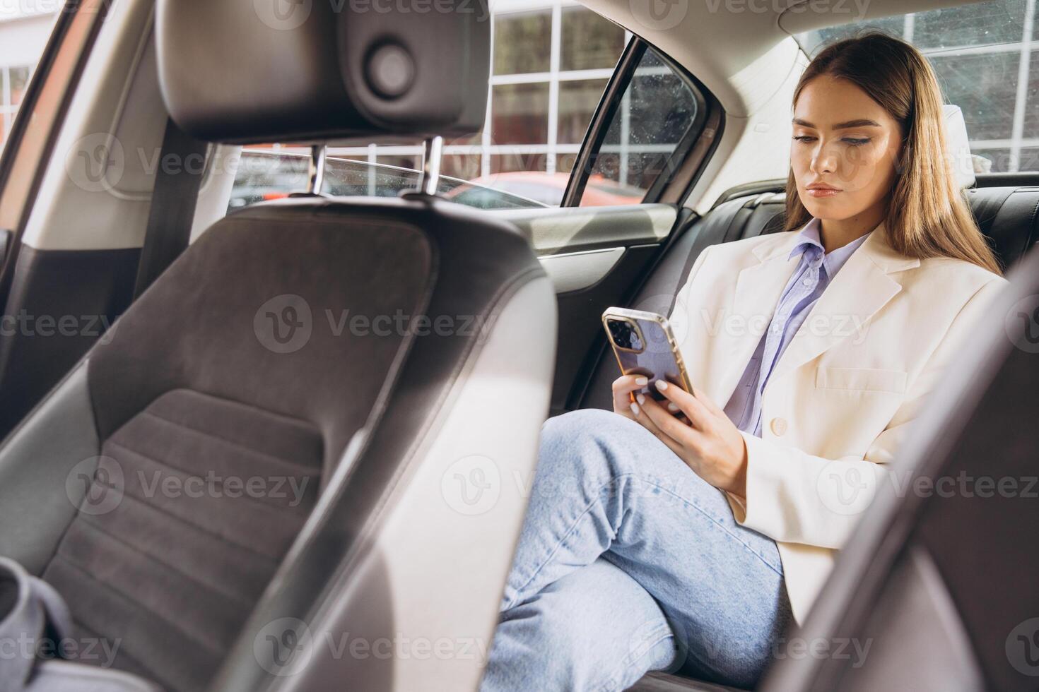 Businesswoman Relaxing in Car Using Smartphone for Communication photo