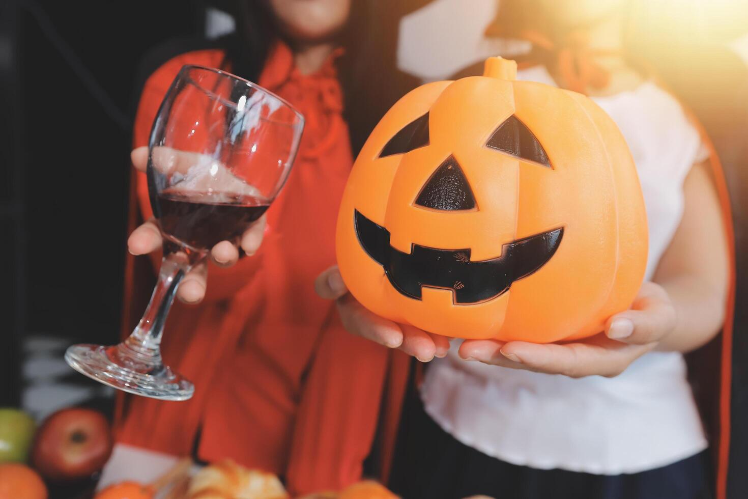 friendship, holiday and people concept - group of happy smiling friends in halloween costumes of vampire, devil, witch and cheetah at home party photo