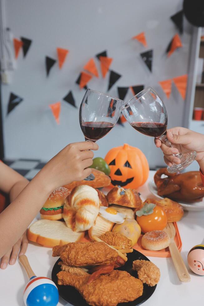 friendship, holiday and people concept - group of happy smiling friends in halloween costumes of vampire, devil, witch and cheetah at home party photo