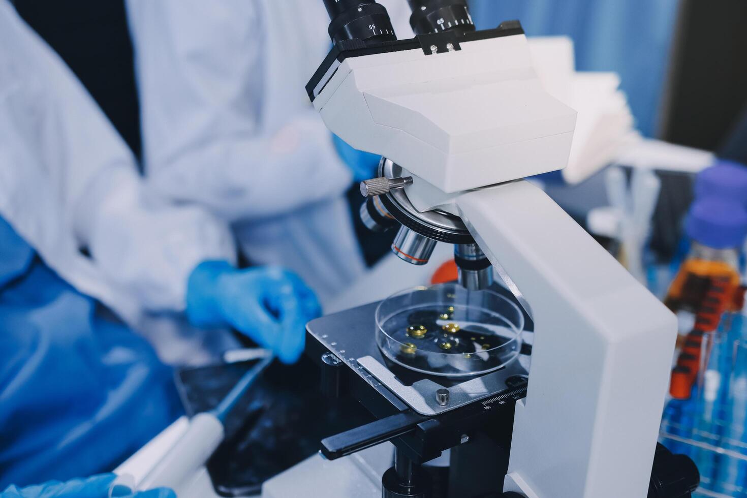 Scientist using microscope in laboratory. Close-up of a researcher's hands adjusting a modern microscope in a lab setting. Science concept photo