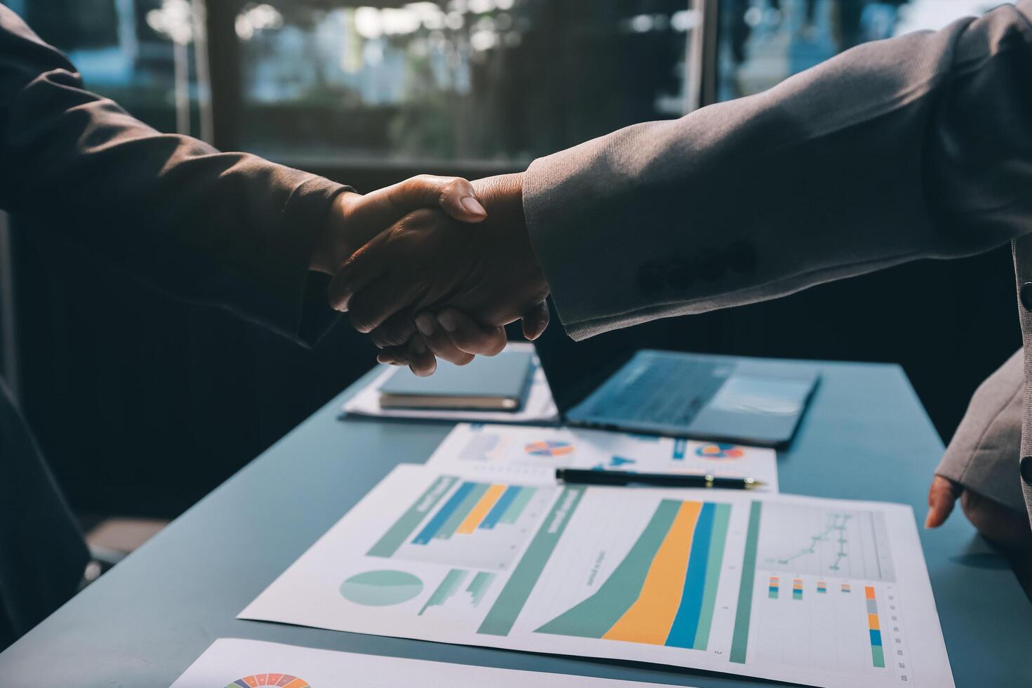 Handshake as successful negotiation ending, close-up. Unknown business people shaking hands after contract signing in modern office photo