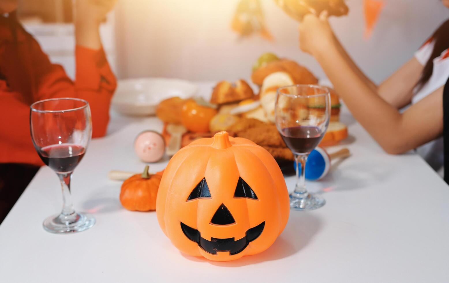 friendship, holiday and people concept - group of happy smiling friends in halloween costumes of vampire, devil, witch and cheetah at home party photo
