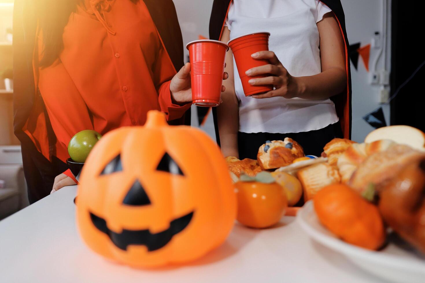 friendship, holiday and people concept - group of happy smiling friends in halloween costumes of vampire, devil, witch and cheetah at home party photo