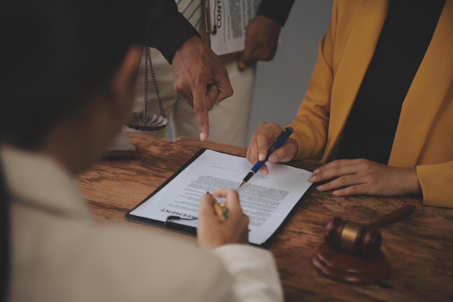 Business and lawyers discussing contract papers with brass scale on desk in office. Law, legal services, advice, justice and law concept picture with film grain effect photo