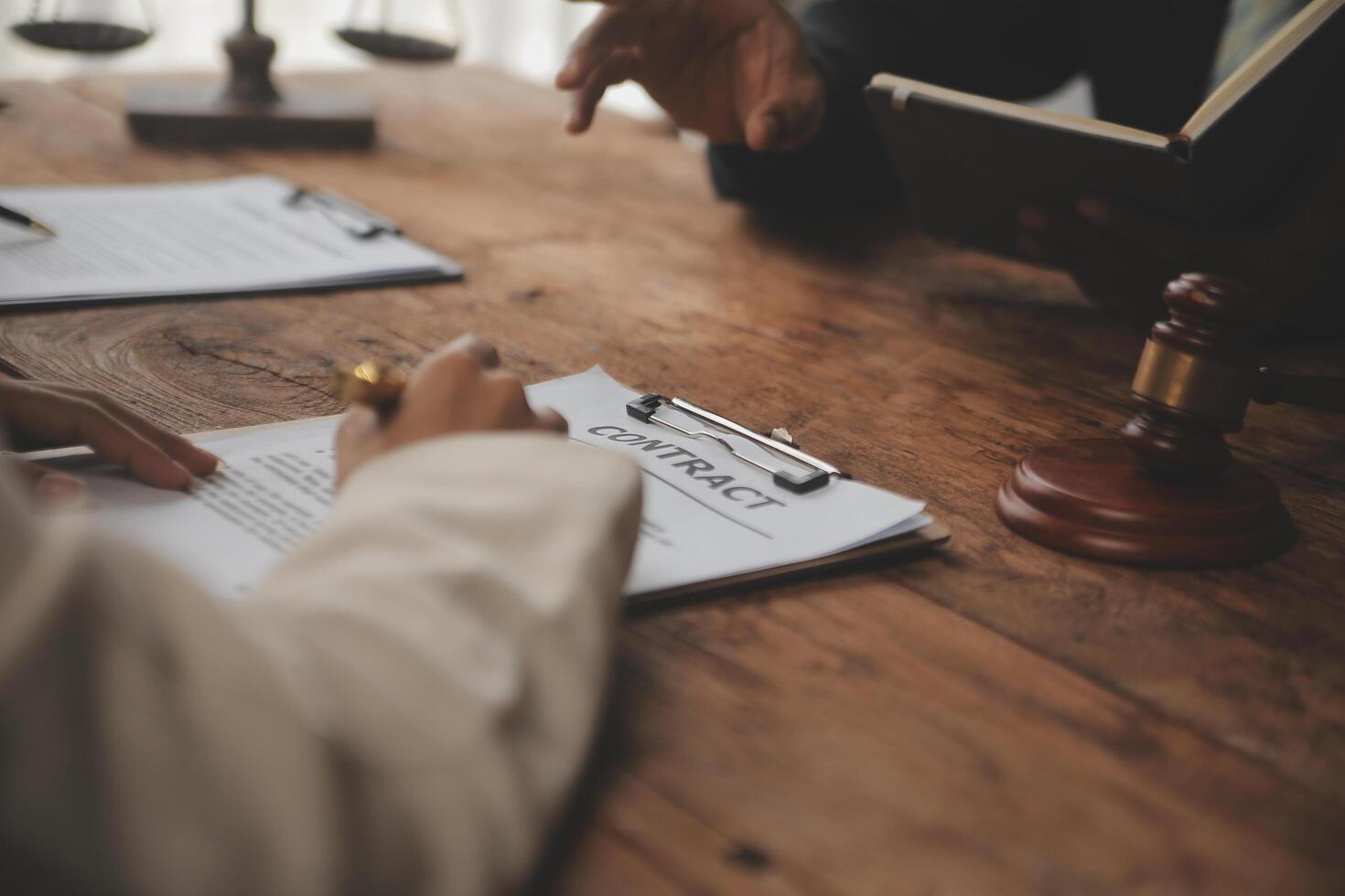 Business and lawyers discussing contract papers with brass scale on desk in office. Law, legal services, advice, justice and law concept picture with film grain effect photo