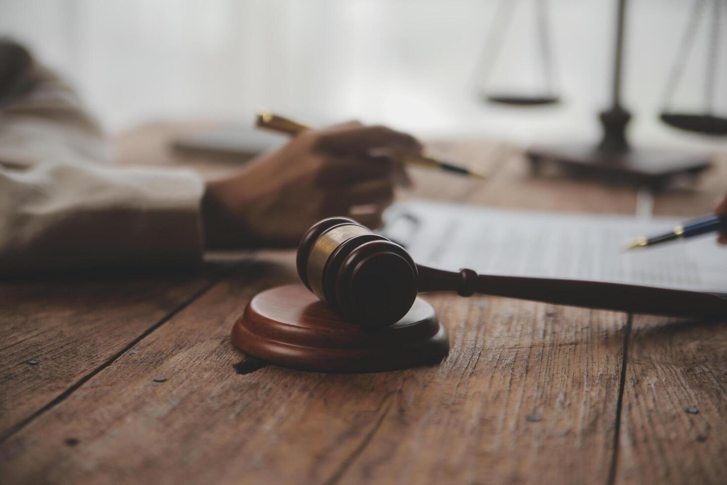 Business and lawyers discussing contract papers with brass scale on desk in office. Law, legal services, advice, justice and law concept picture with film grain effect photo