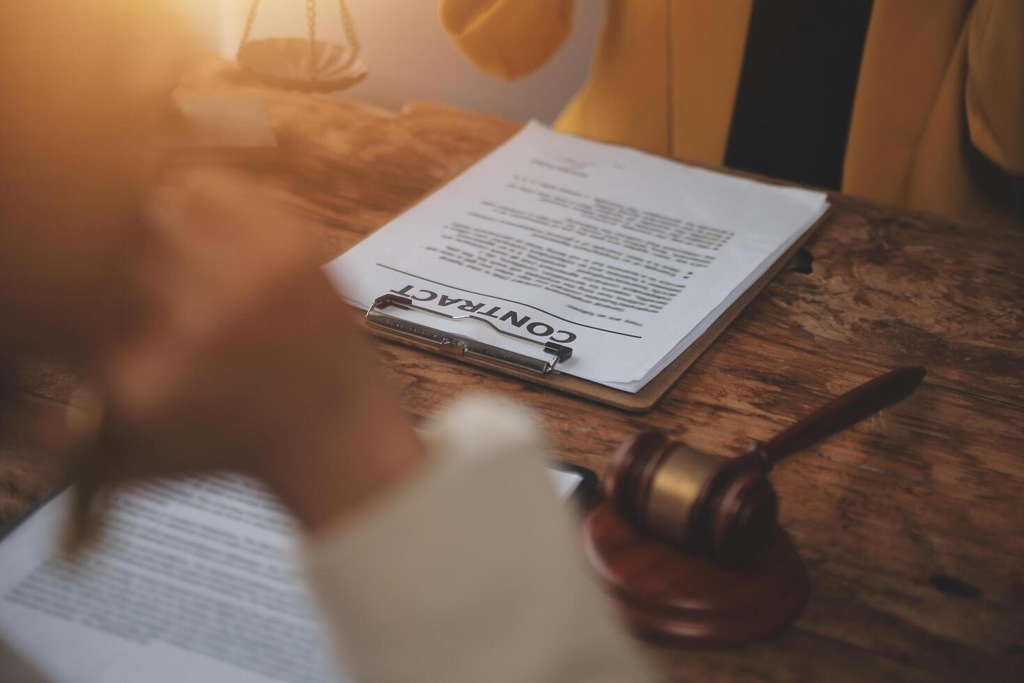 Business and lawyers discussing contract papers with brass scale on desk in office. Law, legal services, advice, justice and law concept picture with film grain effect photo