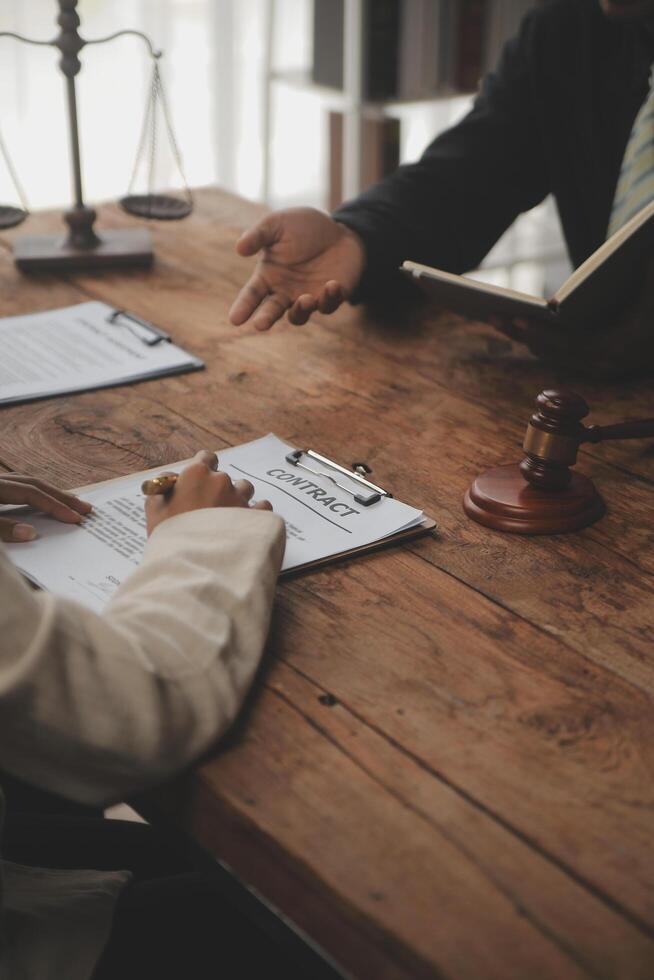 Business and lawyers discussing contract papers with brass scale on desk in office. Law, legal services, advice, justice and law concept picture with film grain effect photo