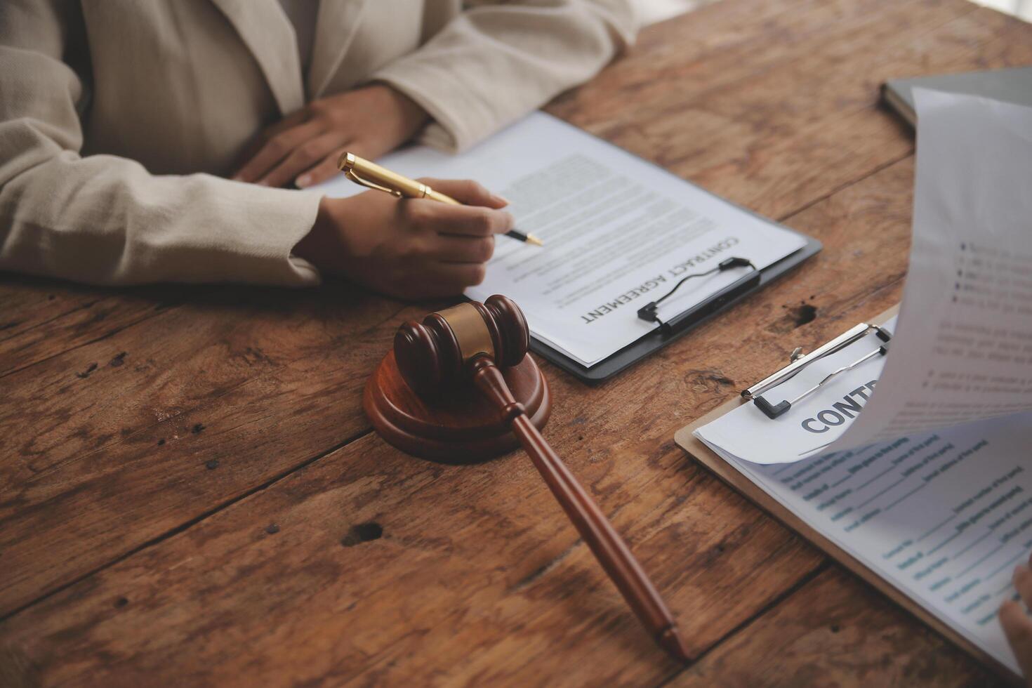 Business and lawyers discussing contract papers with brass scale on desk in office. Law, legal services, advice, justice and law concept picture with film grain effect photo