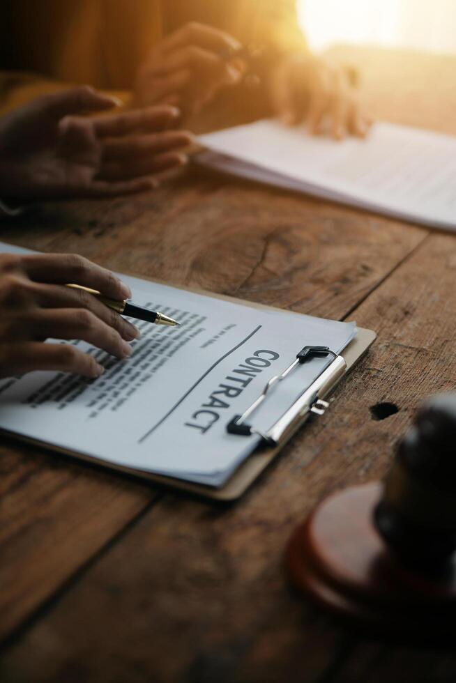 Business and lawyers discussing contract papers with brass scale on desk in office. Law, legal services, advice, justice and law concept picture with film grain effect photo