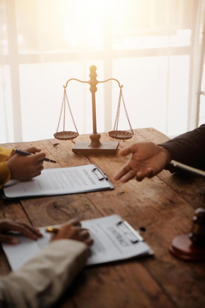 Business and lawyers discussing contract papers with brass scale on desk in office. Law, legal services, advice, justice and law concept picture with film grain effect photo