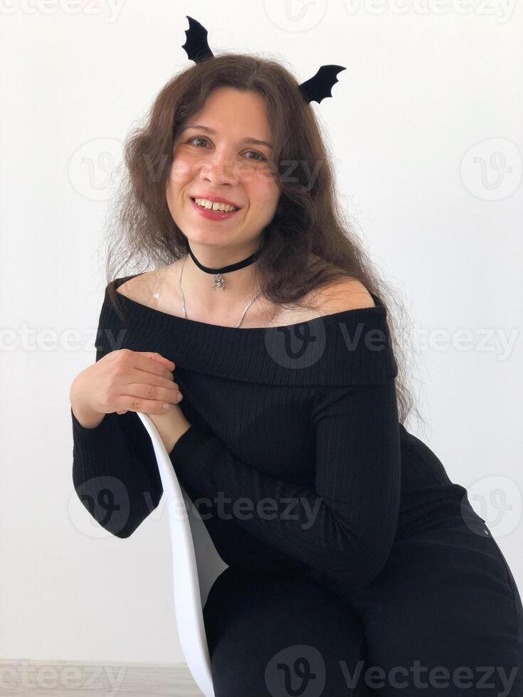 Smiling woman with Halloween bat wings on hair. Halloween, festivity and creativity concept photo